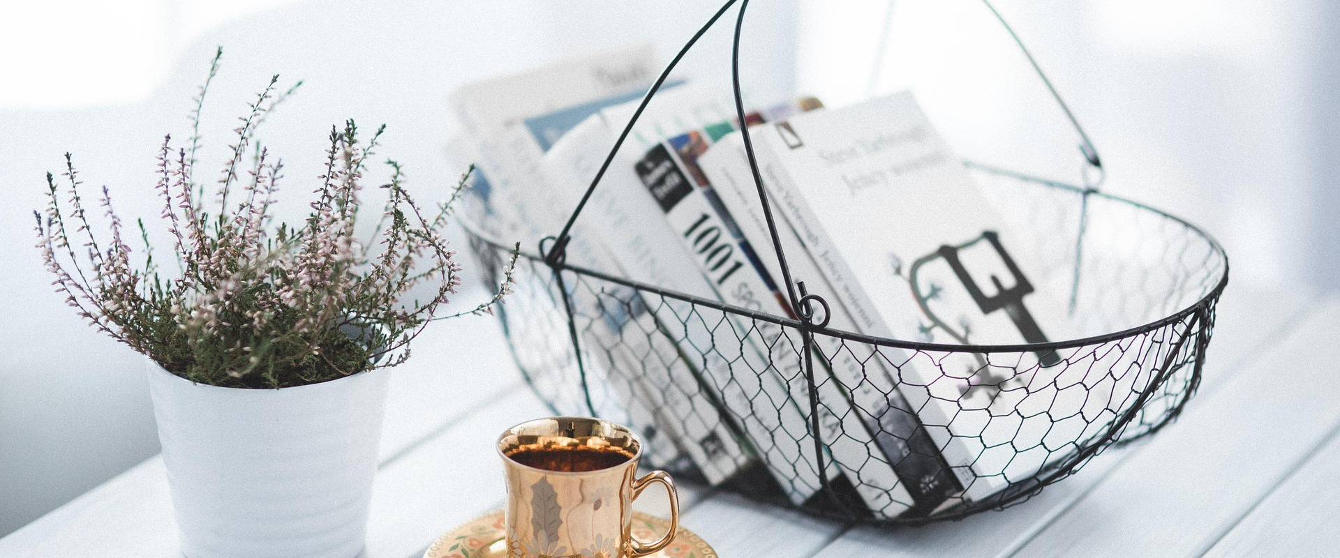 panier avec des livres, une tasse de café et une plante