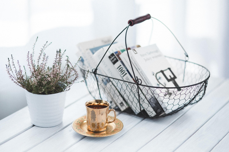 panier avec des livres, une tasse de café et une plante